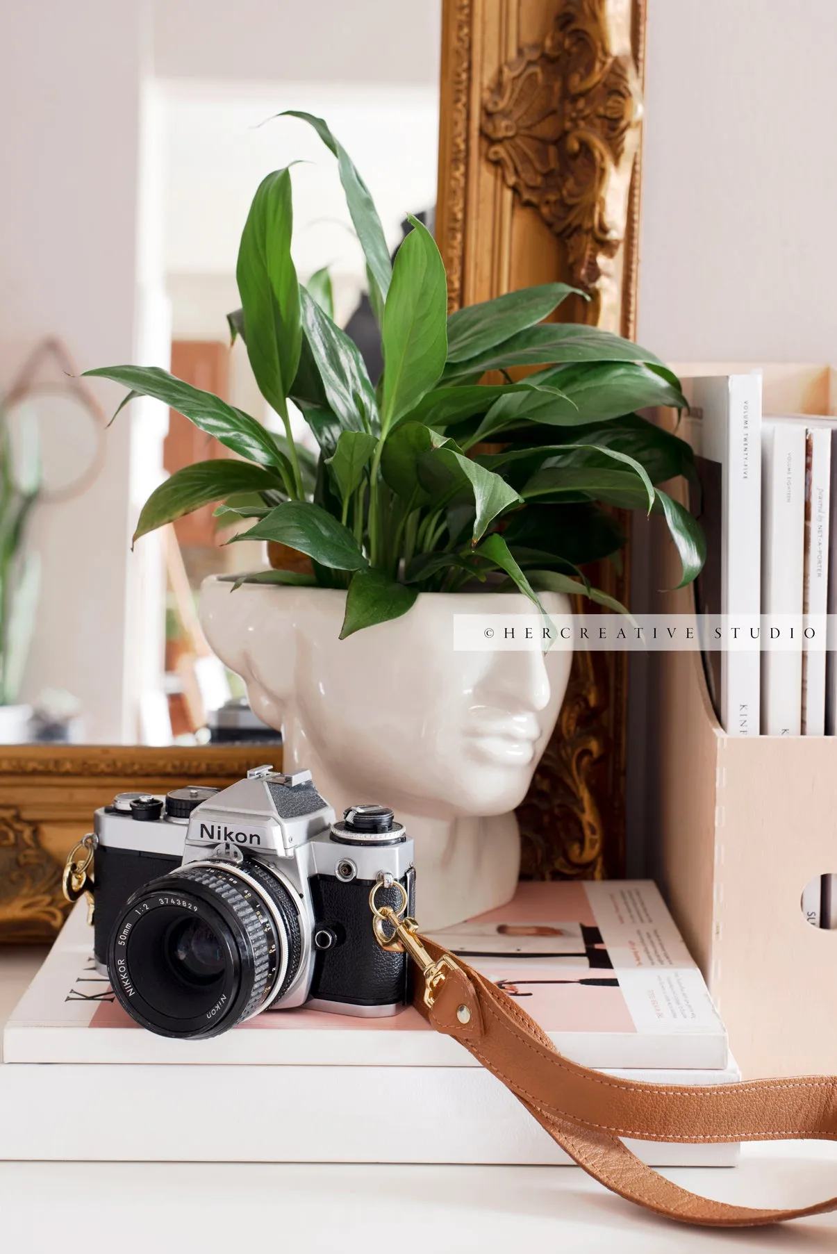 Camera on Table with Gold Mirror. Digital Image.